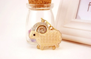 Close-up of golden sheep keychain with sparkling crystals and white enamel finish