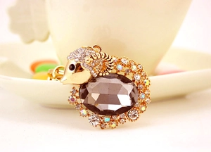 Detailed view of goat keychain featuring grey oval gemstone and sparkling crystals