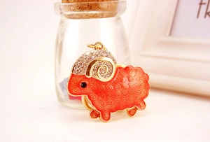 Detailed view of a red enamel goat keychain with sparkling rhinestones and gold-tone metal