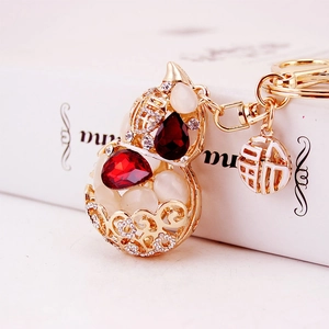 Golden gourd keychain with white opal stones, red crystals and Fu character charm