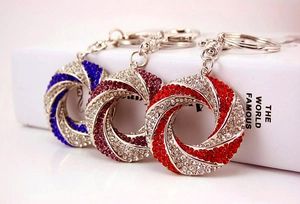 Detail view of rhinestone-encrusted spiral keychains in blue, purple, and red colors