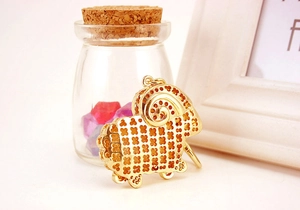 Detailed macro view of a golden goat keychain with clover patterns and spiral horns