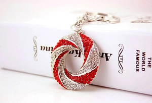 Detail of twisted silver metal keychain with inlaid red and clear rhinestones