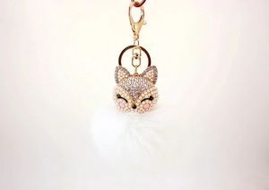 Detail of fox head keychain with rhinestones, pearls and a large white fur pompom