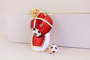 Detailed close-up of red and white football cap keychain with rhinestones and gold buckle