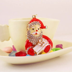 Sparkling Christmas Santa keychain with rhinestones and red enamel on a cozy background