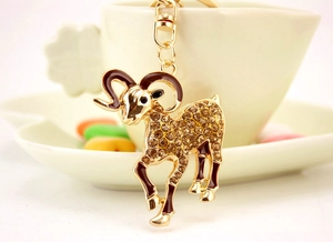 Detailansicht vom Ziegen-Schlüsselanhänger mit Strass an einer cremeweißen Kaffeetasse