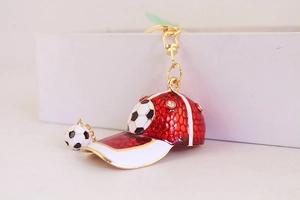 Detail of red football cap keychain with gold plating and sparkling crystal accents