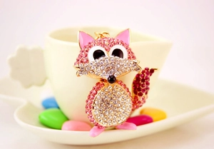 Detail of cute gold-plated fox keychain with sparkling pink and clear crystals