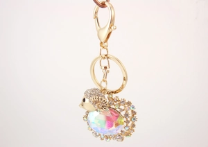 Detail of goat keychain featuring white rhinestones and a large iridescent crystal gem