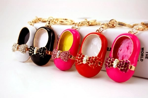 Close-up of colorful enamel shoe keychains with crystal bows and gold hardware