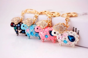 Dettaglio di quattro portachiavi a pecora con strass nero blu rosa e bianco e base oro