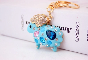 Dettaglio portachiavi pecora blu con cuori rosa e strass luccicanti su lega dorata