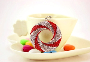 Detailed macro view of spiral paved rhinestone ring charm with red and clear crystals