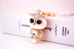 Vue détaillée du porte-clés hibou avec émail, yeux en cristal vert et cœur en strass