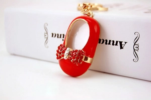 Detail of red miniature shoe keychain featuring sparkling rhinestones and golden hardware