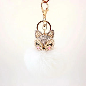 Sparkling fox head keychain with white faux fur pompom and elegant gold hardware decoration