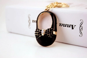 Close-up of black Mary Jane shoe keychain with sparkling rhinestones and golden metal hardware