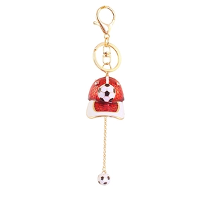 Detail of red football cap keychain with white brim and gold link chain ornament