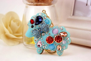 Close-up of blue sheep keychain with colorful rhinestones and gold Zhaocai characters