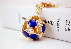 Detailaufnahme vom goldenen Fußball-Schlüsselanhänger mit blauem Emaille und Strass