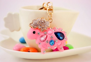 Détail d'un porte-clés mouton rose avec des strass et des accents de pierres précieuses