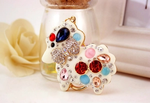 Detail of creative sheep keychain featuring colorful inlaid crystals and golden metal ring