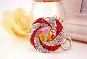 Detailed view of circular rhinestone keychain with red and silver crystals in warm setting