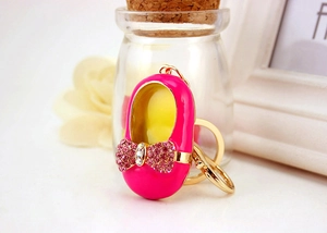Detailed close-up of a pink ballet shoe keychain with rhinestone bow and gold-tone clasp