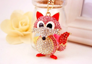 Close-up of a cute fox keychain with sparkling pink rhinestones and gold-tone metal