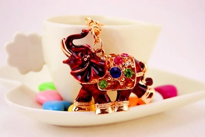 Detail of a golden elephant keychain with red enamel and vibrant multi-colored rhinestones
