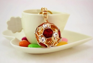 Detail eines funkelnden Strass-Fußball-Schlüsselanhängers mit Emaille an einer Tasse