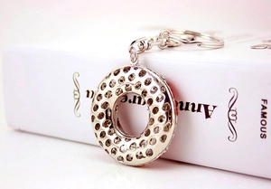 Detailed macro view of donut-shaped metal keychain with red and white inlaid rhinestones