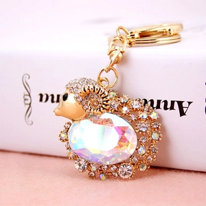 Golden goat keychain with sparkling crystals and rainbow gemstone on a soft background