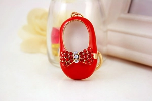 Close-up of a red high heel shoe keychain with rhinestone bow and gold-plated finish