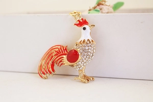 Close-up of rooster keychain with red enamel wings and sparkling crystal rhinestones