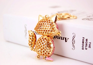 Detailed back view of fox keychain featuring hollow clover patterns and pink crystal stones