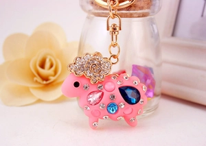 Détail d'un porte-clés mouton rose orné de strass colorés et d'un anneau doré