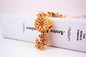 Detail of creative duck keychain with clover hollow pattern and gold-tone lobster clasp