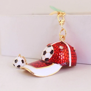 Creative red baseball cap keychain with football charm and rhinestones in gold finish