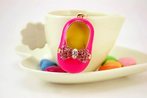 Detailed macro view of pink enamel shoe keychain with sparkling rhinestone bow detail