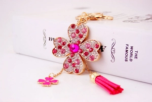 Dettaglio portachiavi a quadrifoglio con strass rosa, base dorata e nappa in pelle