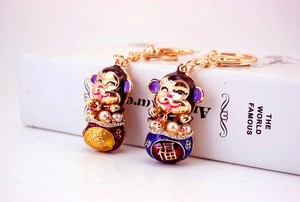 Detail of cartoon monkey keychains with enamel finish, pearls, and crystals