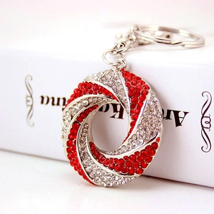 Elegant round silver metal keychain with red and white sparkling rhinestone vortex