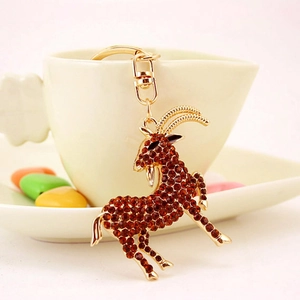 Simpatico portachiavi zodiaco capra dorato con strass rossi su una tazza bianca