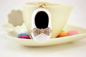 Detail of creative ballet shoe keychain with rhinestone bow and gold metal ring