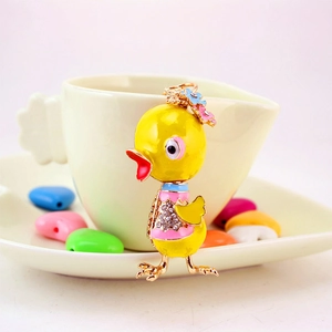 Cute yellow duck keychain with rhinestones and floral details on a white background
