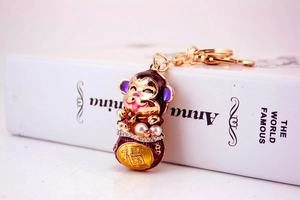 Macro shot of gold-plated monkey keychain with pink crystals and pearls