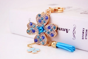 Dettaglio macro del portachiavi a quadrifoglio con strass blu e nappa raffinata