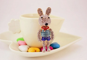 Macro detail of cartoon rabbit pendant featuring intricate rhinestones and gold alloy